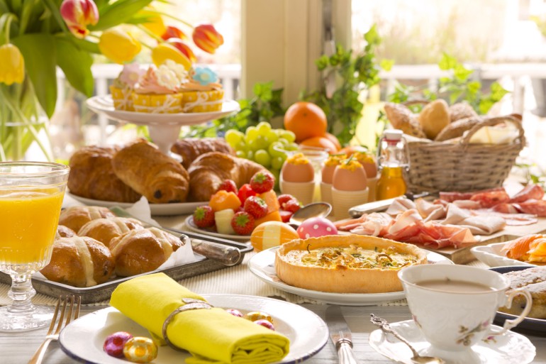 Breakfast or brunch table filled with all sorts of delicious delicatessen ready for an Easter meal.