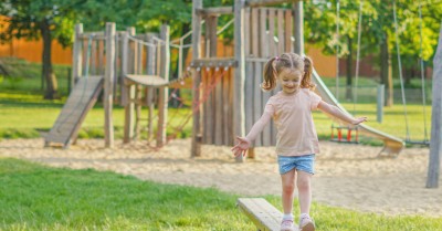 Little girl walks on a play on the park